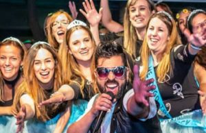 Animador con micrófono junto a un grupo de asistentes en una celebración