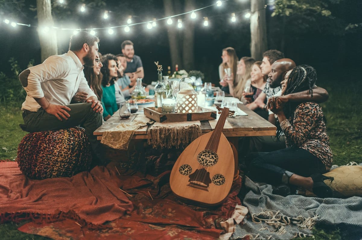 Grupo de amigos reunido alrededor de una mesa en una cena al aire libre