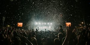 Público y escenario iluminado en un festival de música, fotografía ilustrativa