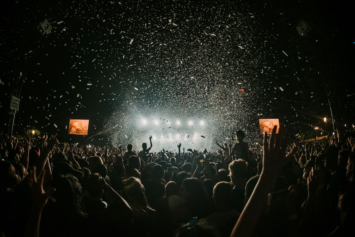 Público frente a un escenario iluminado en un festival de música