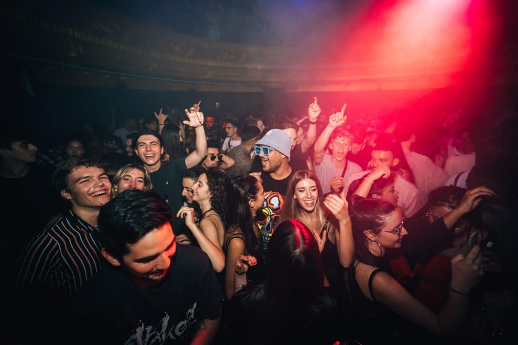 Público disfrutando de una sesión de club en Teatro Eslava, con luces rojas y azules